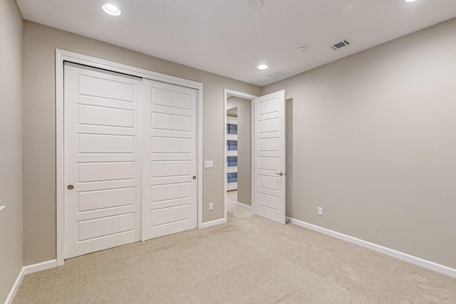 unfurnished bedroom with light carpet, visible vents, and baseboards