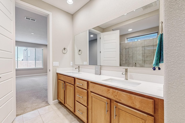 full bath featuring double vanity, a shower stall, visible vents, and a sink