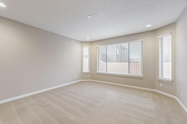 unfurnished room featuring recessed lighting, carpet flooring, a textured ceiling, and baseboards