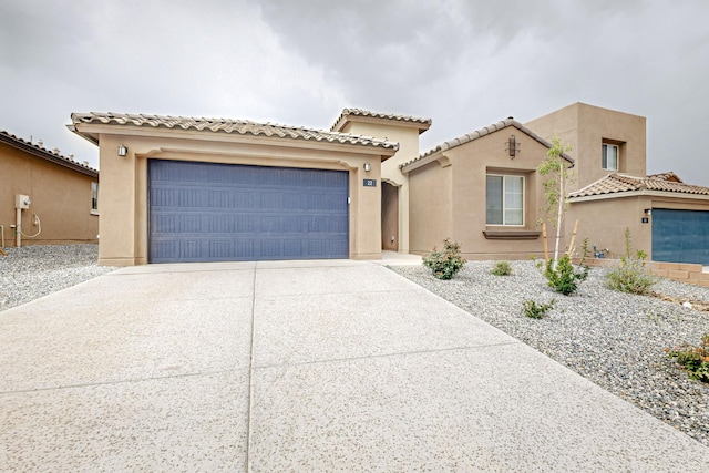 view of front of property with driveway, an attached garage, and stucco siding