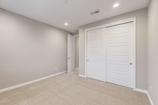 unfurnished bedroom with recessed lighting, a closet, visible vents, light carpet, and baseboards