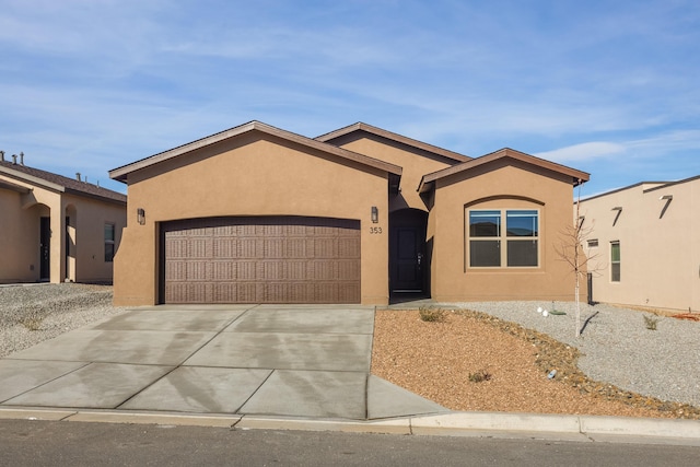 view of front of house featuring a garage, driveway, and stucco siding