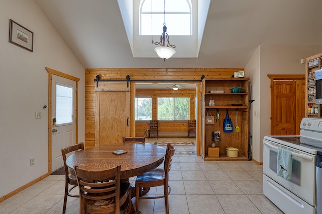 dining space featuring light tile patterned flooring, wooden walls, a barn door, and vaulted ceiling