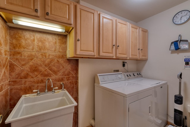 clothes washing area featuring sink, cabinets, and independent washer and dryer