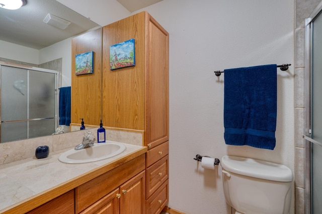 bathroom with a stall shower, visible vents, vanity, and toilet