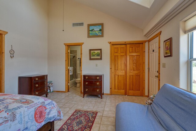 tiled bedroom with high vaulted ceiling and connected bathroom