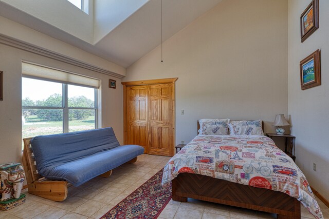 tiled bedroom featuring high vaulted ceiling