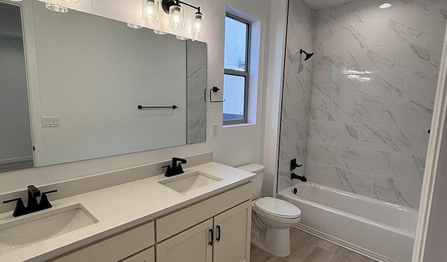 bathroom featuring a sink, toilet, double vanity, and wood finished floors