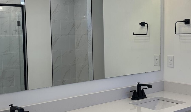 bathroom with a stall shower and a sink