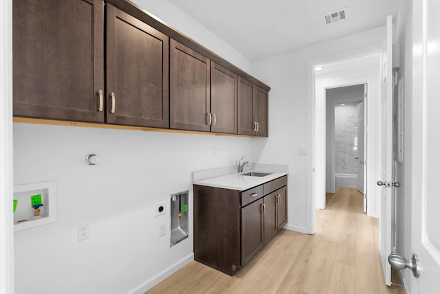 laundry room with light wood-type flooring, cabinet space, visible vents, and electric dryer hookup