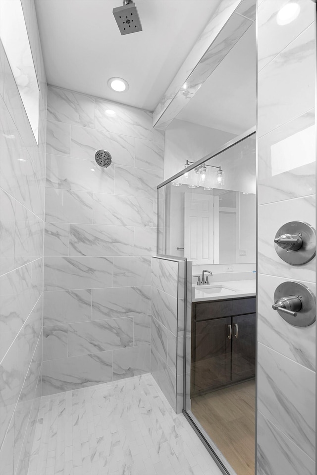 bathroom with vanity and a marble finish shower