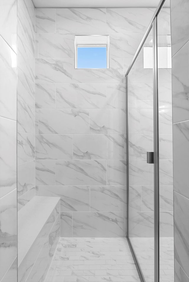 bathroom featuring a marble finish shower