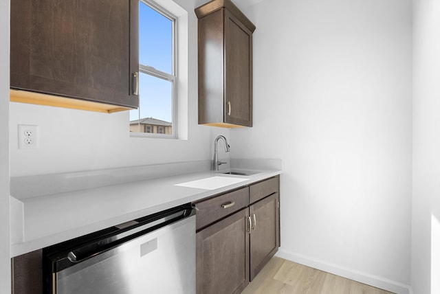 kitchen with light wood-style flooring, a sink, light countertops, dark brown cabinets, and dishwasher