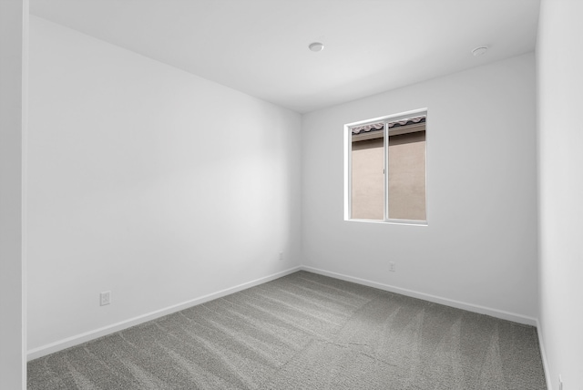 unfurnished room with carpet and baseboards