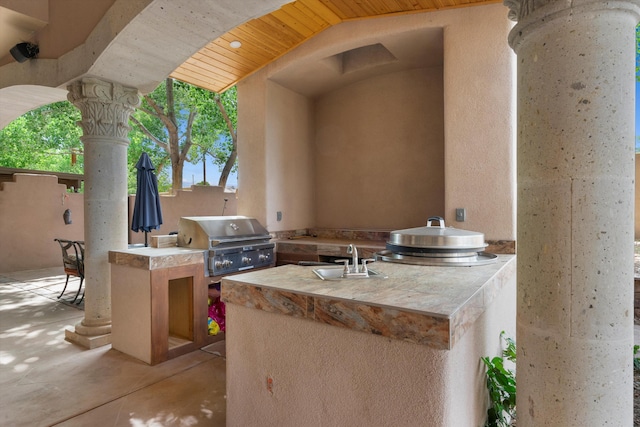 view of patio with grilling area, area for grilling, and a sink