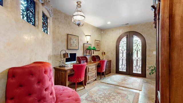 office featuring arched walkways, stone tile floors, and french doors