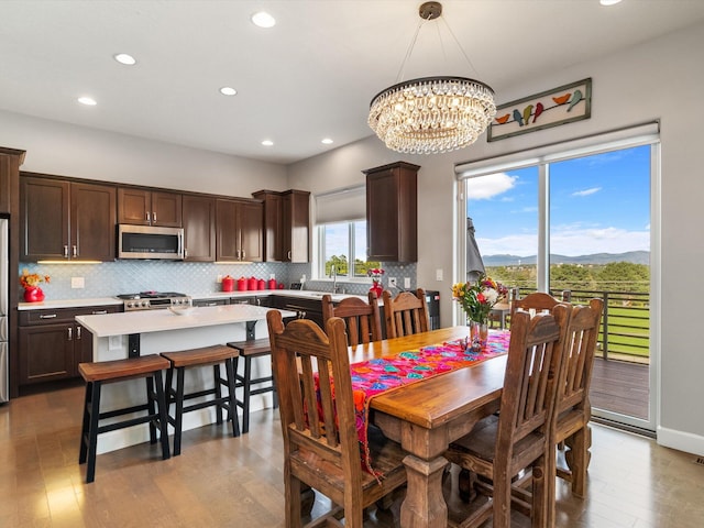 dining area with a mountain view, light hardwood / wood-style floors, and an inviting chandelier