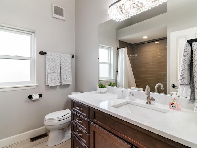 bathroom featuring vanity, toilet, walk in shower, and a chandelier