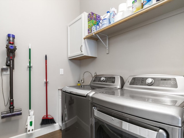 laundry area featuring cabinets, independent washer and dryer, and dark hardwood / wood-style flooring