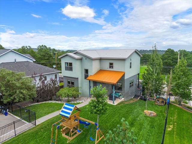 back of property featuring a patio area, a playground, and a yard