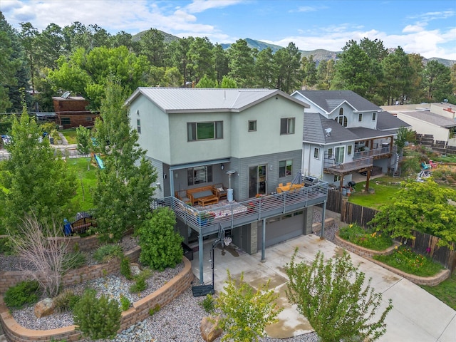 back of house with a mountain view and a garage