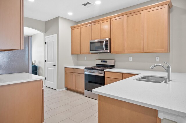 kitchen featuring light tile patterned floors, sink, stainless steel appliances, and light brown cabinets