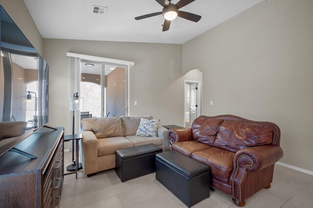 tiled living room with ceiling fan and lofted ceiling