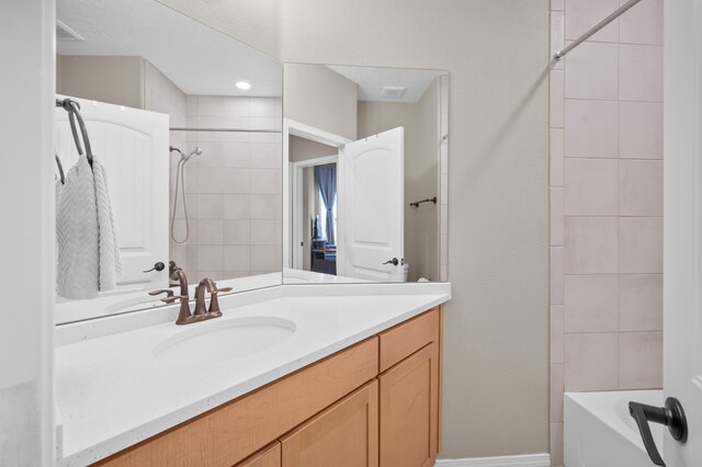 bathroom featuring vanity and tiled shower / bath combo