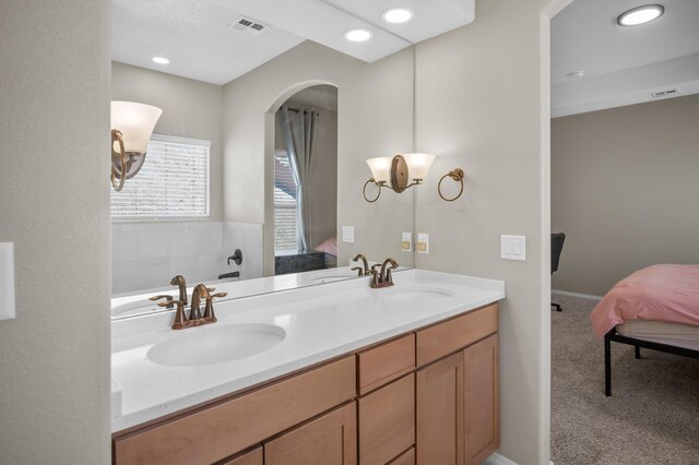 bathroom with a bathing tub, dual vanity, and an inviting chandelier