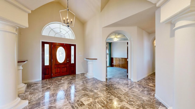 entryway featuring tile patterned floors, high vaulted ceiling, and ornate columns