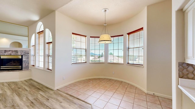 dining space with a high end fireplace and light hardwood / wood-style floors