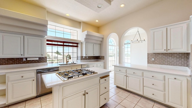 kitchen with light tile patterned floors, sink, stainless steel appliances, and backsplash