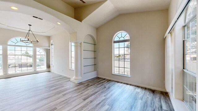 interior space with decorative columns, hardwood / wood-style floors, and a chandelier