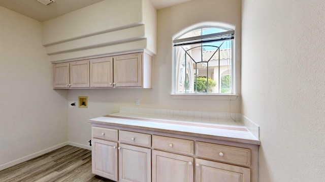 laundry area featuring cabinets, washer hookup, electric dryer hookup, and light hardwood / wood-style floors