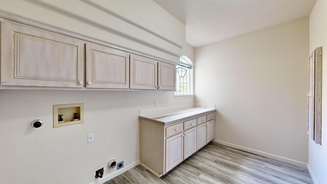 laundry area with light wood-type flooring, cabinets, hookup for a washing machine, and hookup for a gas dryer