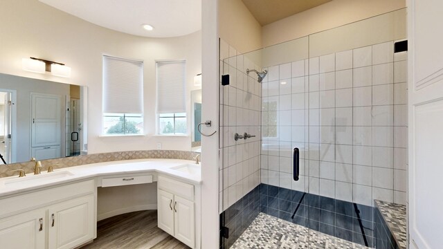 bathroom featuring a shower with shower door, hardwood / wood-style flooring, and vanity