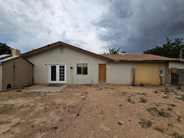 rear view of property with a patio area, french doors, and stucco siding