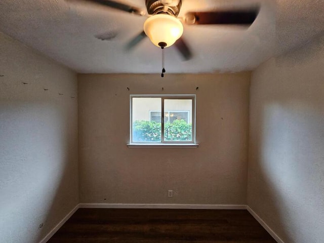 empty room with wood finished floors, baseboards, and ceiling fan