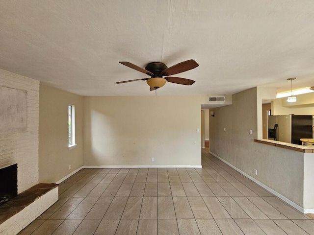 unfurnished living room with visible vents, a ceiling fan, a fireplace, and a textured ceiling