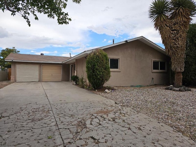 view of front of house with a garage, driveway, and stucco siding