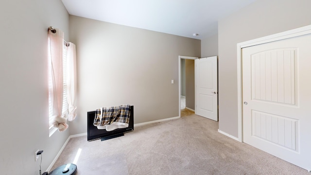 unfurnished bedroom with light carpet and a closet