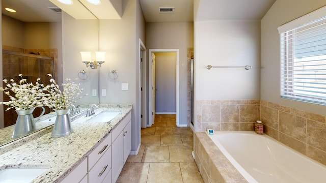 bathroom featuring a relaxing tiled tub, double sink vanity, and tile patterned floors