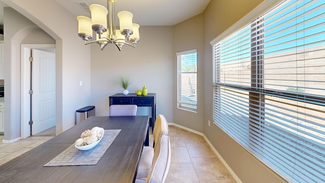 dining space featuring light tile patterned floors and a notable chandelier