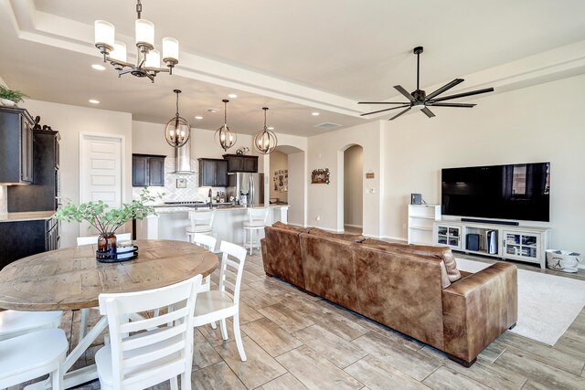 living room featuring light hardwood / wood-style flooring and ceiling fan with notable chandelier