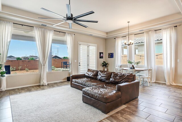 living room featuring ceiling fan with notable chandelier, hardwood / wood-style flooring, and a healthy amount of sunlight