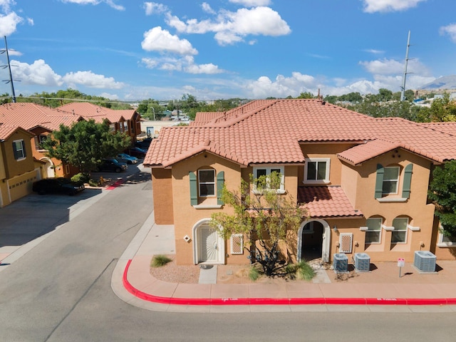 mediterranean / spanish-style house with central AC and a garage