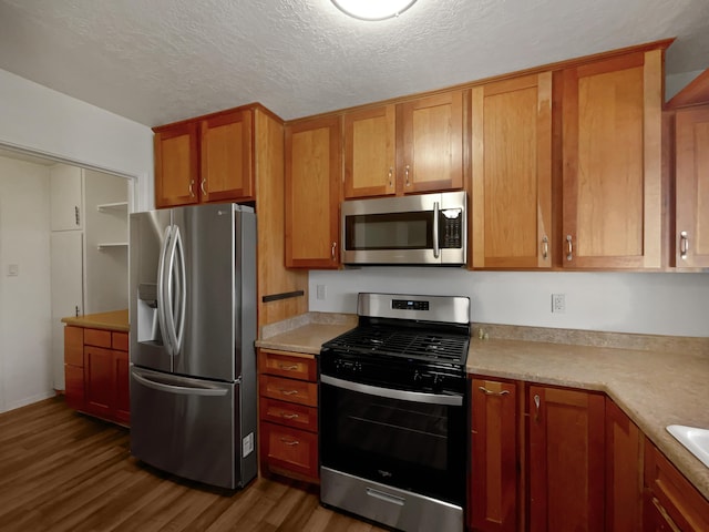 kitchen with stainless steel appliances, brown cabinetry, light countertops, and dark wood finished floors