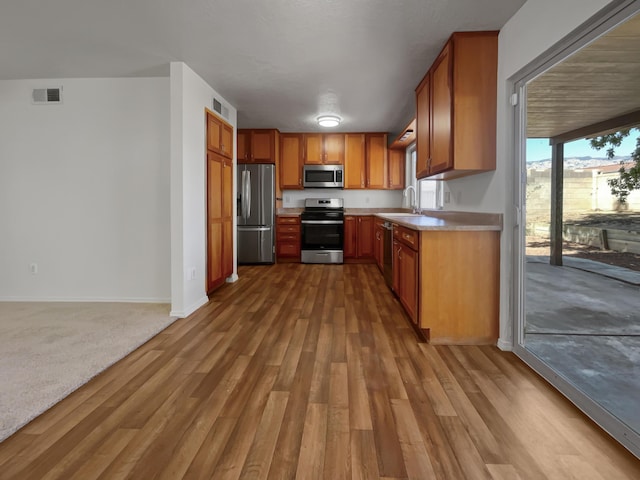 kitchen with dark wood finished floors, visible vents, stainless steel appliances, and light countertops