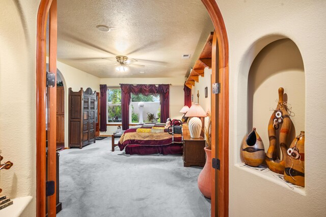 bedroom featuring a textured ceiling, carpet flooring, and ceiling fan