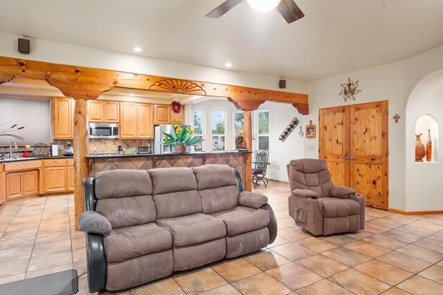 living room with sink, ceiling fan, and light tile patterned floors